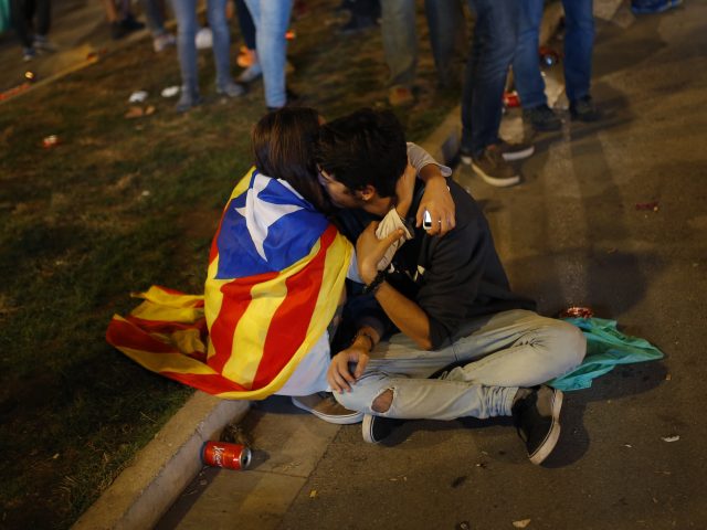 A couple with a Catalan flag embrace during a rally in Barcelona