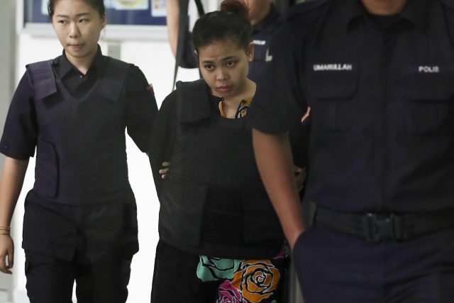 Siti Aisyah is escorted by police as she leaves court