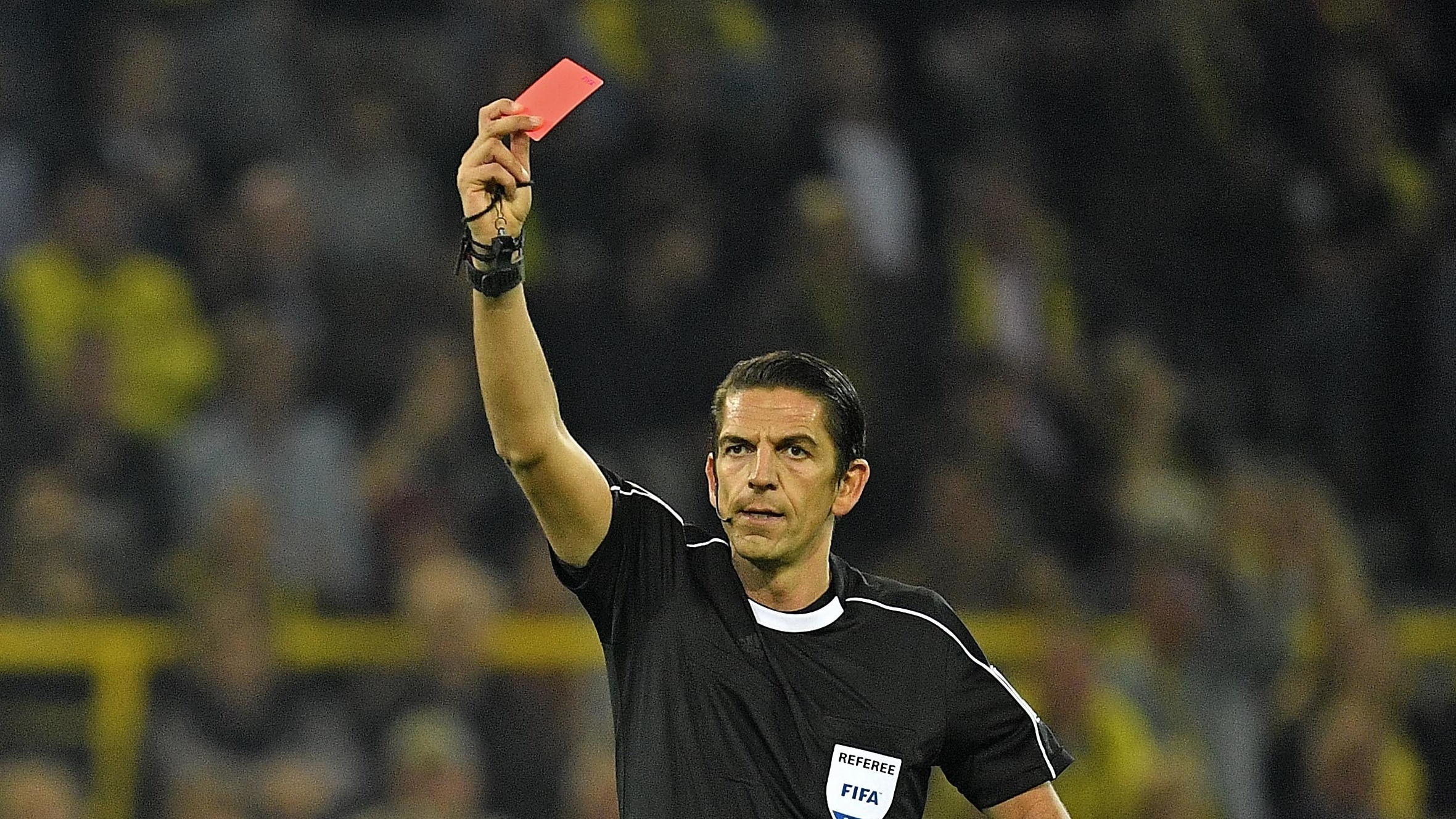 Referee Deniz Aytekin shows a red card during a Bundesliga game