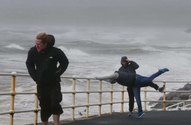 People battle the waves and high wind at Lahinch in County Clare on the West Coast of Ireland