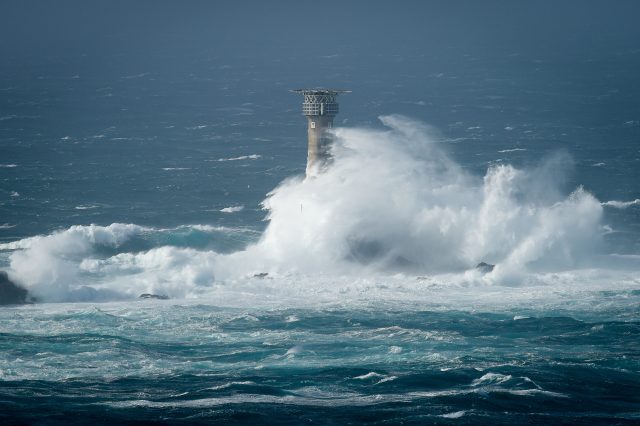 Waves break on Longships lighthouse off the coast of Lands End, Cornwall