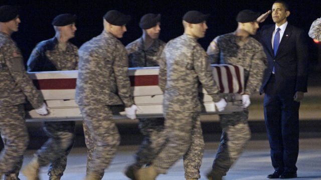 President Barack Obama salutes as a soldier is repatriated at Dover Air Force Base