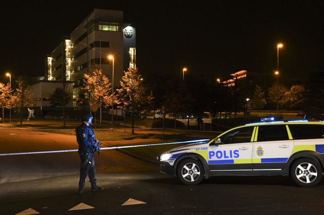 A police officer stands guard outside a cordoned off area surrounding a police station in Helsingborg, Sweden (Johan Nilsson via TT News Agency via AP)