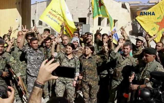 Fighters from the Syrian Democratic Forces celebrate their victory in Raqqa (Hawar News Agency/AP)