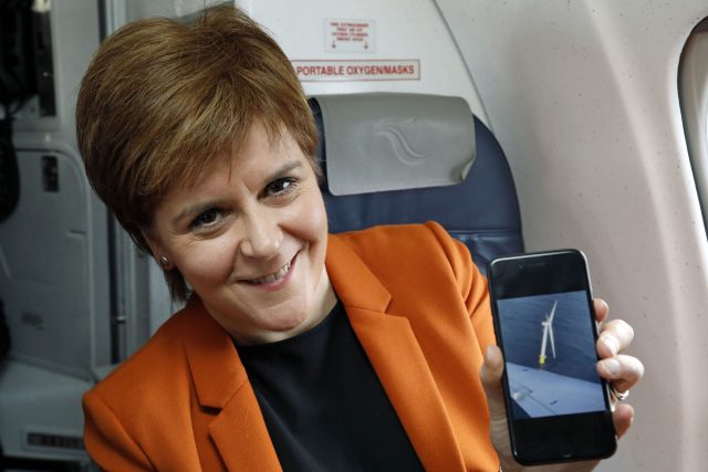 Nicola Sturgeon smiles after taking a picture on her mobile phone as she flew over the world's first floating wind farm (Scottish Government/PA)