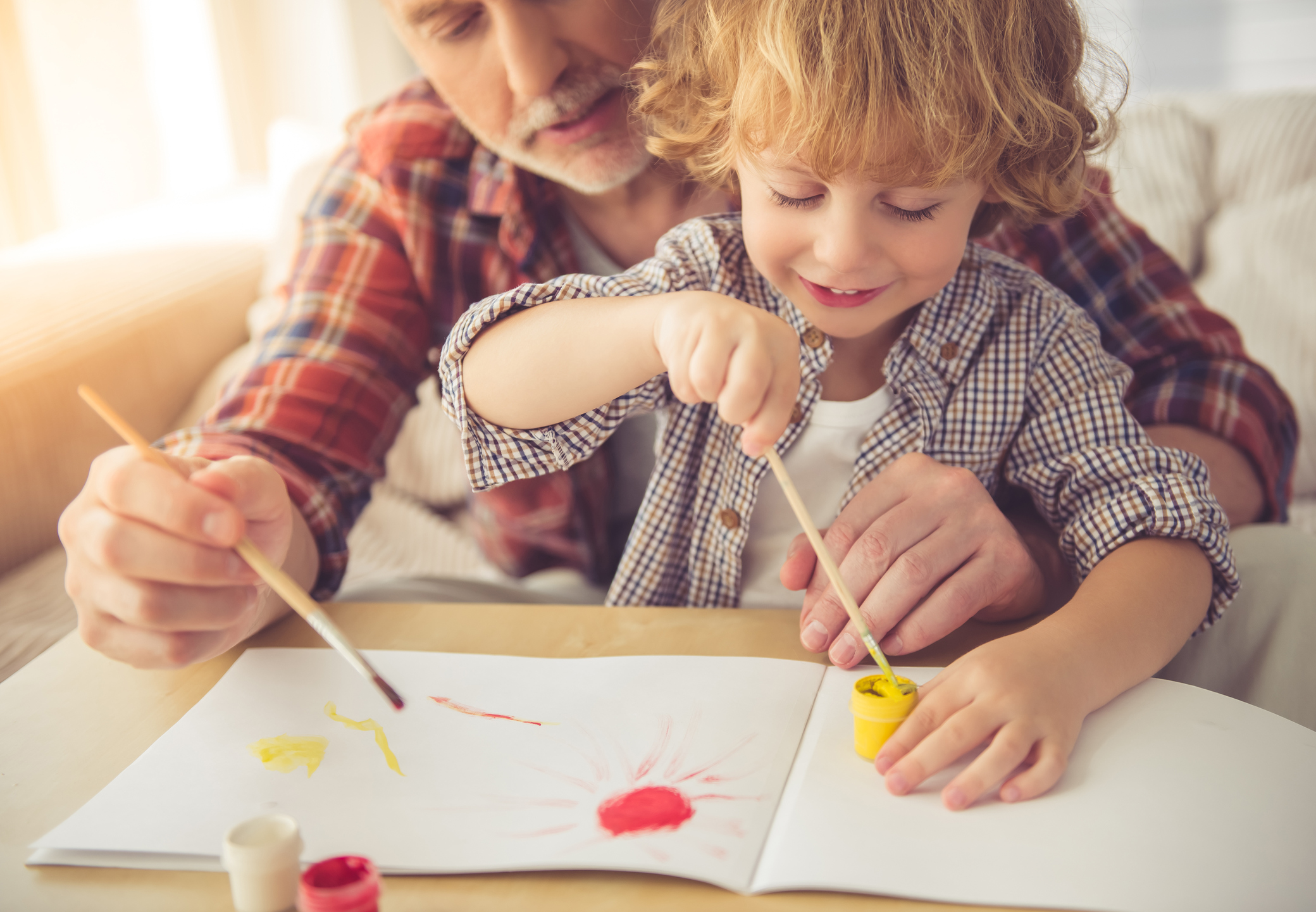 A grandad helps his grandson do some painting (Thinkstock/PA)