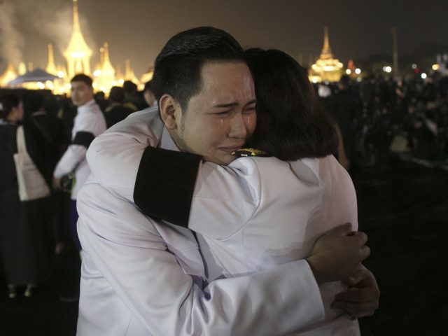 Officials hug near the royal crematorium