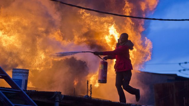 A man tries to extinguish the fire set during clashes in Nairobi