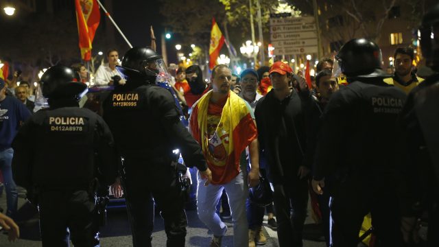 Catalan police stands preventing demonstrators from moving forward during a march against the unilateral declaration of independence