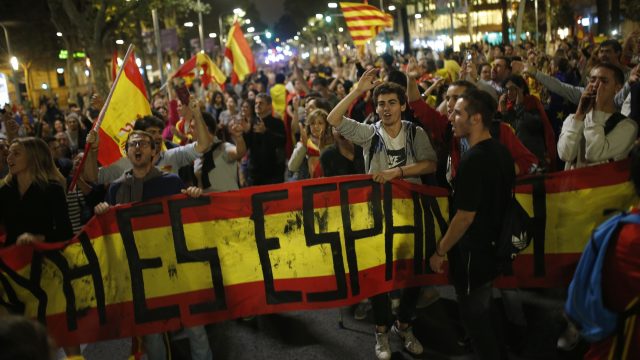 Anti-independence supporters shout slogans and wave Spanish flags as they march against the unilateral declaration of independence