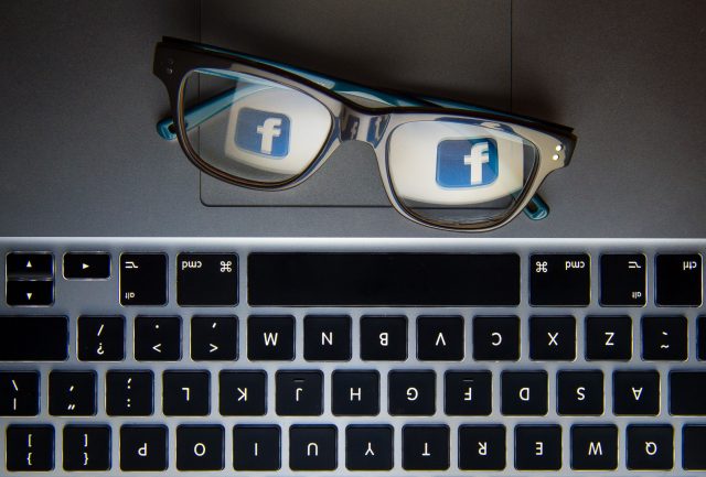 A Facebook logo reflected in glasses