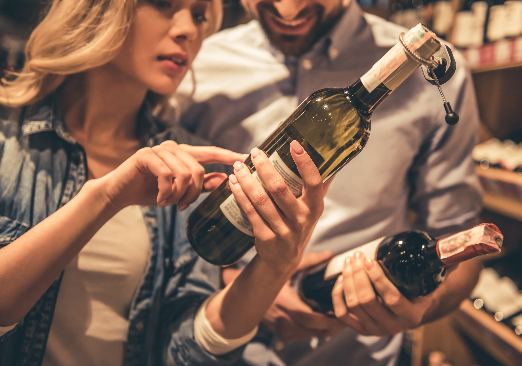 Beautiful young couple is talking and smiling while choosing wine at the supermarket (Thinkstock/PA)