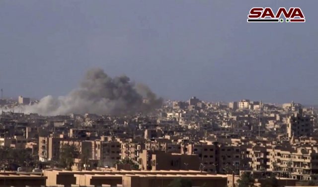 Smoke and debris rises after Syrian government shelling of Deir el-Zour city 