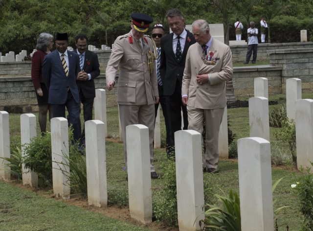 The Prince of Wales looks at the gravestone of Squadron Leader ASK Scarf VC during a visit to the Commonwealth War Graves in Taiping.