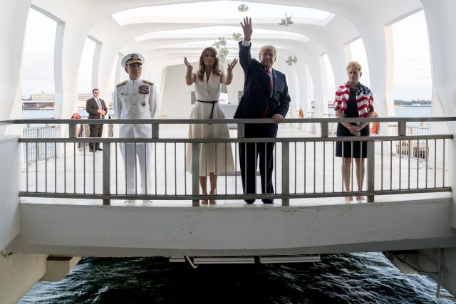 Donald and Melania Trump, accompanied by Command Commander Admiral Harry Harris and his wife Bruni Bradley, throw flower pedals while visiting the Pearl Harbour Memorial 