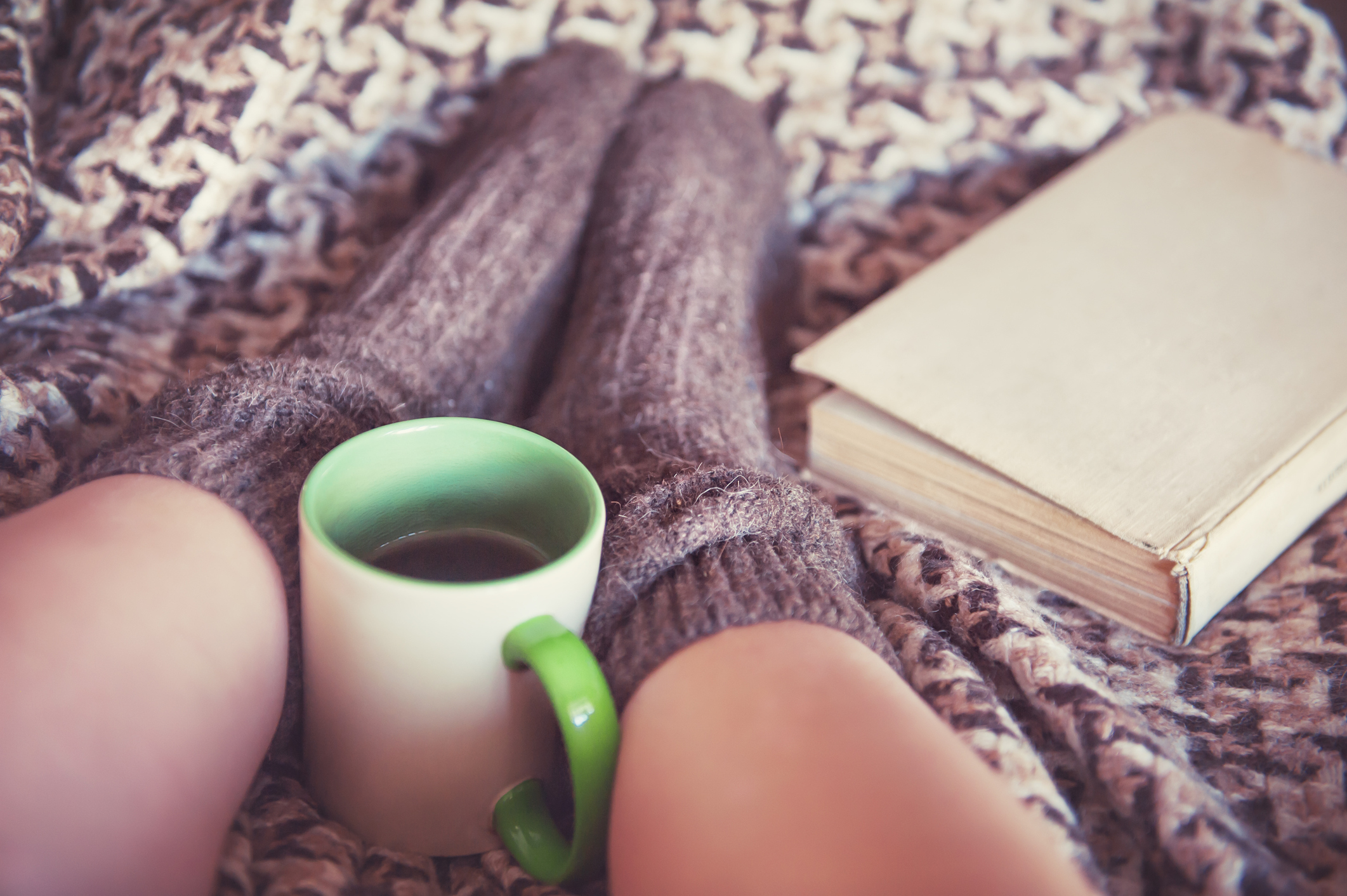 Woman in woollen socks with old book and a cup of tea (Thinkstock/PA)