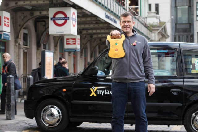 London black cab driver John Hamilton holds a defibrillator  (PA)