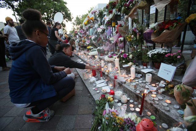 People lay flowers and tributes outside Notting Hill Methodist Church, close to Grenfell Tower in west London