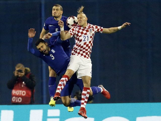 Croatia defender Domagoj Vida challenges for the ball with two Greece players