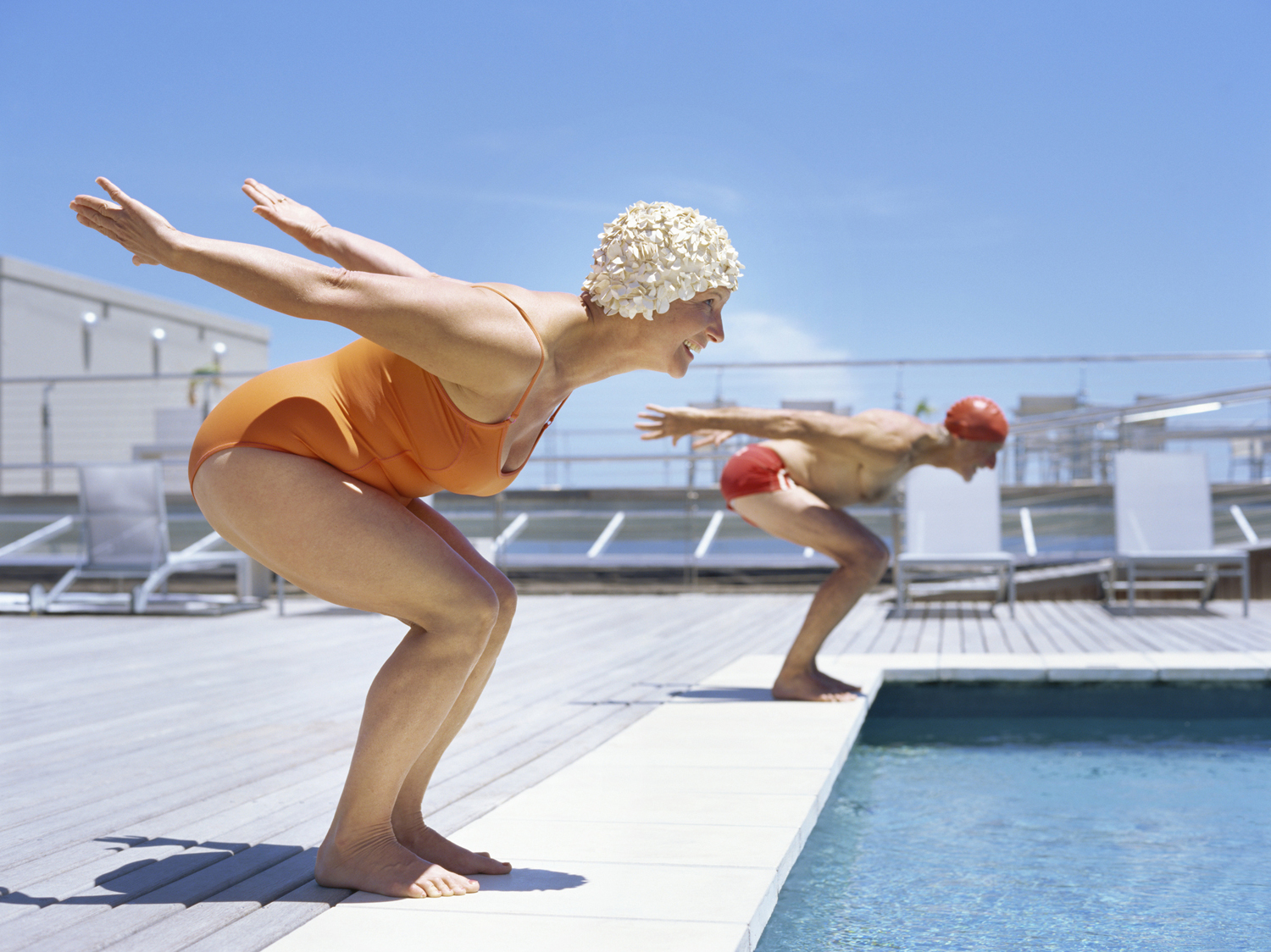 Senior couple ready to dive in to swimming pool