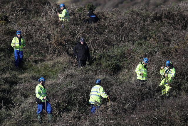 Police perform a fingertip search in the open space above the coast near to Swanage 