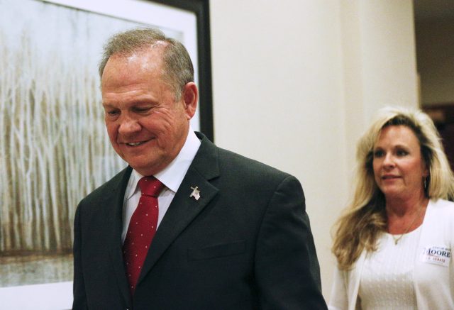 Roy Moore, followed by his wife Kayla, arrives to speak at a news conference in Birmingham, Alabama