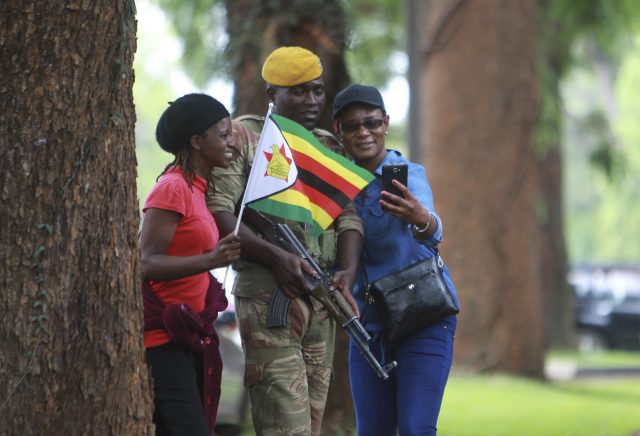 Marchers pose for pictures with armed soldiers
