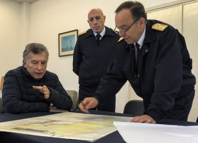 Navy base Chief Gabriel Martin Gonzalez, right, talks to Argentina's President Mauricio Macri over a map at the naval base 