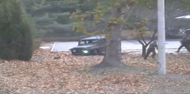 The North Korean soldier runs from a jeep 