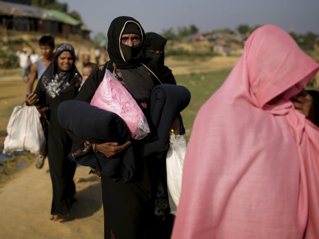 Rohingya Muslims carry supplies from the Kutupalong refugee camp in Bangladesh