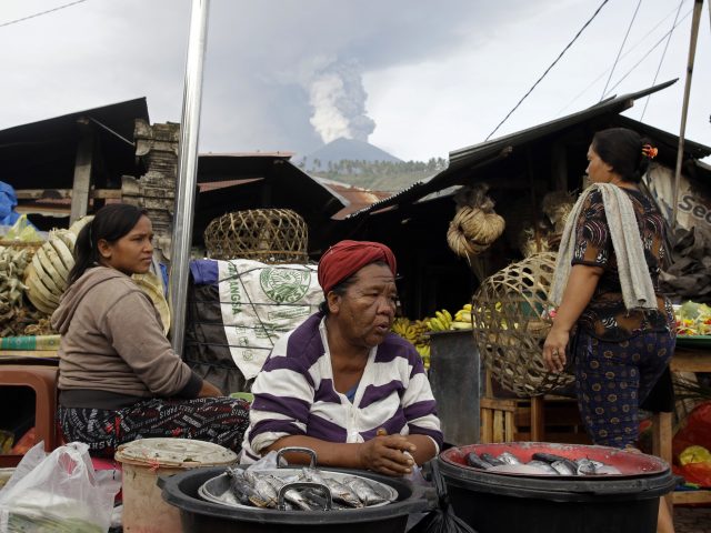 Residents work at a market near the volcano 