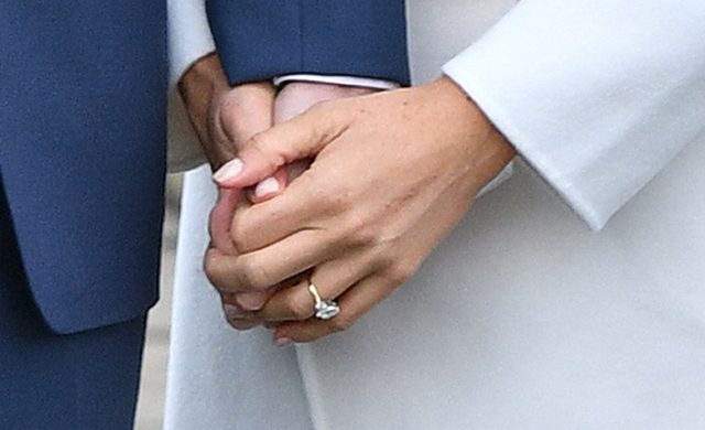 Prince Harry and Meghan Markle holding hands with the ring on show at Kensington Palace
