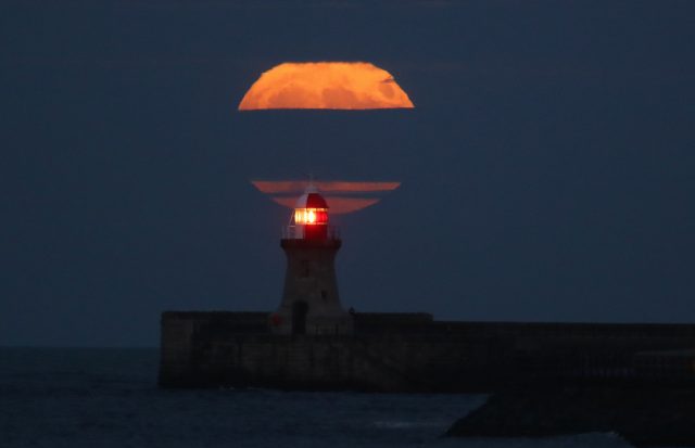 The winter supermoon rises over the lighthouse at South Shields (Owen Humphreys/PA)
