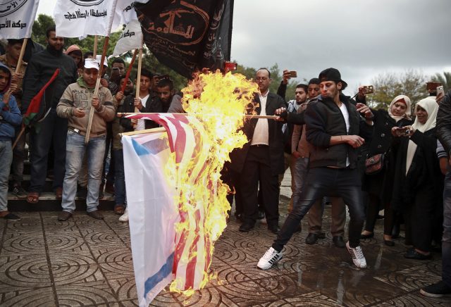 Palestinian demonstrators burn representations of Israeli and American flags  (Khalil Hamra/AP)