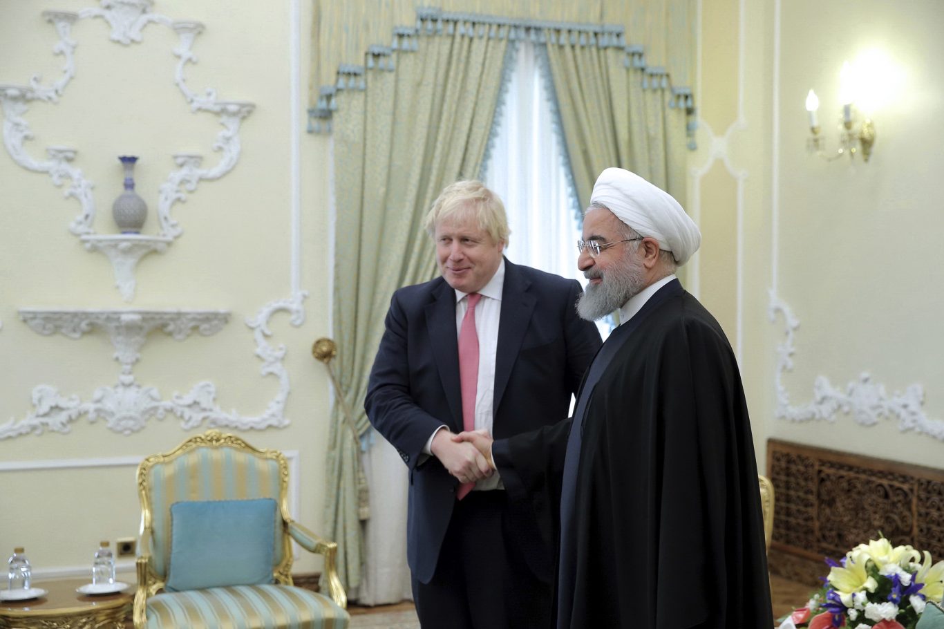 Iranian President Hassan Rouhani greets Boris Johnson at the start of their meeting in Tehran (Iranian Presidency Office via AP)