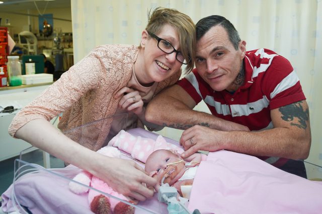 Naomi Findlay and Dean Wilkins, at Glenfield Hospital in Leicester with their daughter (Ben Birchall/PA)