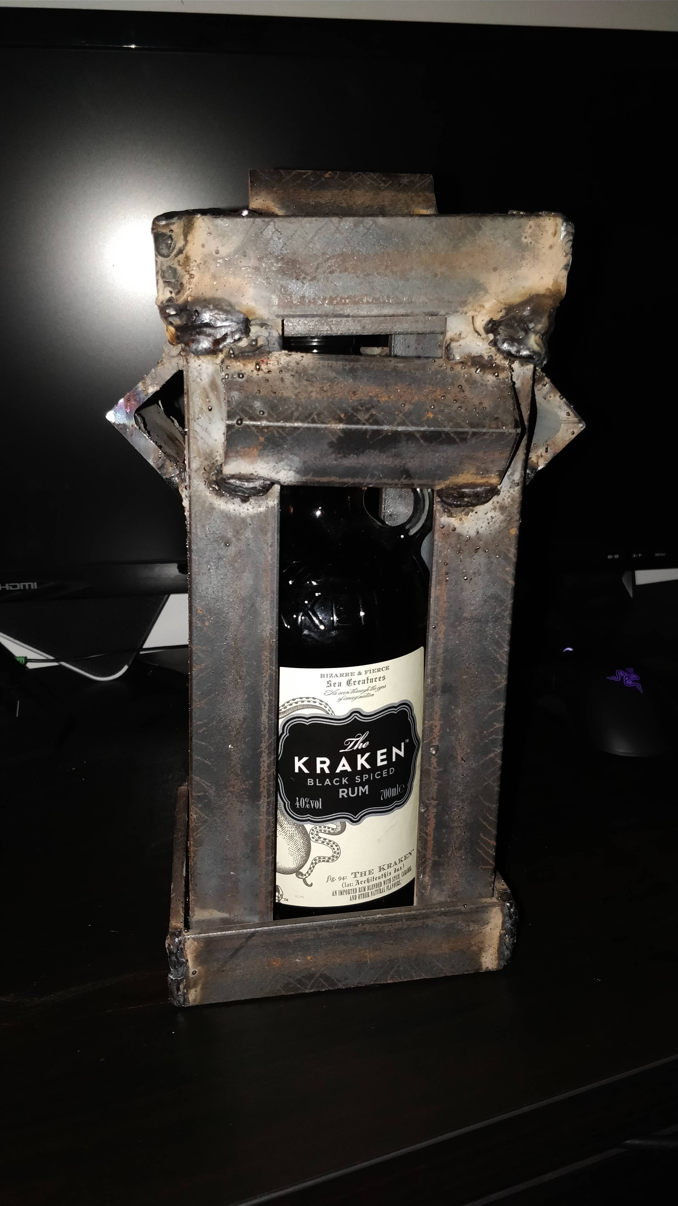 A bottle of Kraken rum wrapped in metal