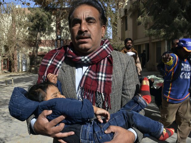 A man rescues a child after a suicide bombing in Pakistan (Arshad Butt/AP/PA)