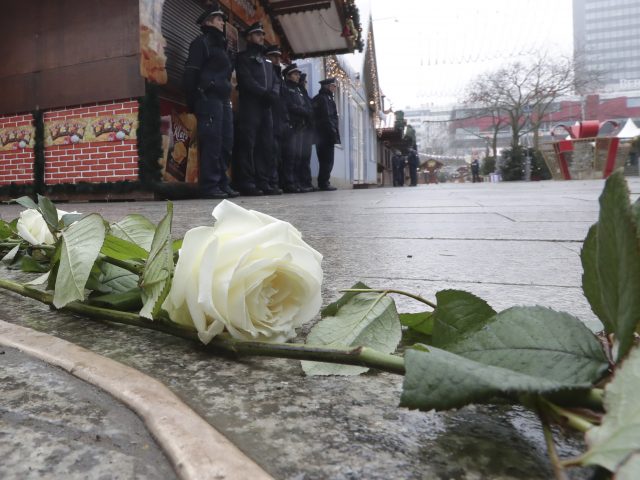 White roses sit beside a new memorial - a crack in the ground filled with gold - on the first anniversary of the Berlin Chrismas Market attack (Michael Sohn/AP/PA)