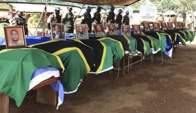 UN peacekeepers stand behind the coffins of Tanzanian peacekeepers killed by rebels during a memorial ceremony in Beni (Al-Hadji Kudra Maliro/AP)