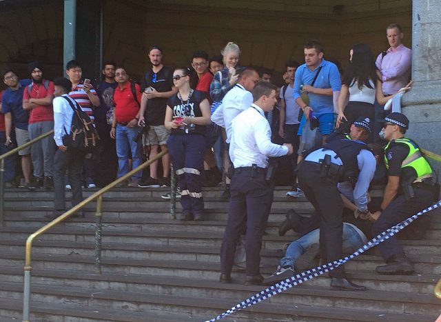 Police arrest a man on the steps of Flinders Street station in Melbourne (Andrew Lund/PA)