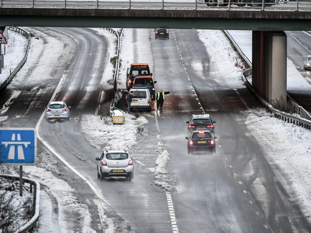 A man warns motorists to pass slowly following an incident on the A417 between Gloucester and Cheltenham (Ben Birchall/PA)