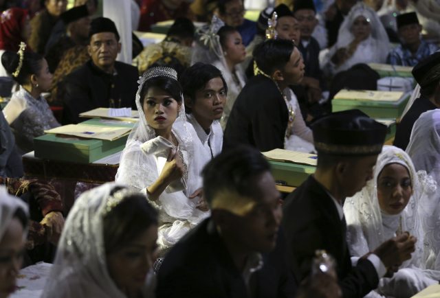 Couples wait for their turn to get married during a mass wedding held in celebration of the New Year in Jakarta, Indonesia (Dita Alangkara/AP)