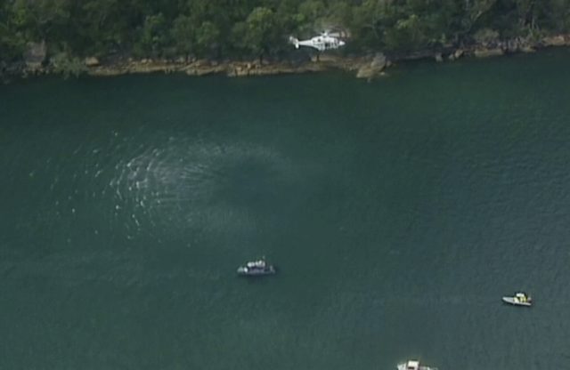 A search and rescue helicopter flies above search boats in Hawkesbury River (Australian Media via Pool/PA) 