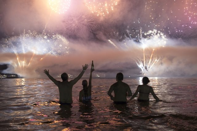 People watch fireworks exploding over Copacabana beach (Leo Correa/AP)