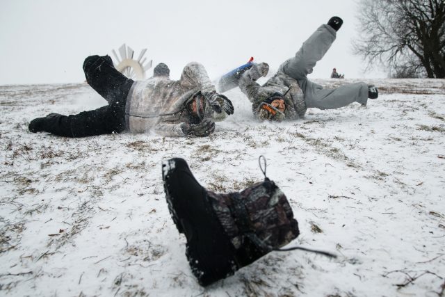 Two boys crash down a snowy bank in Iowa  (Brian Powers/The Des Moines Register via AP)