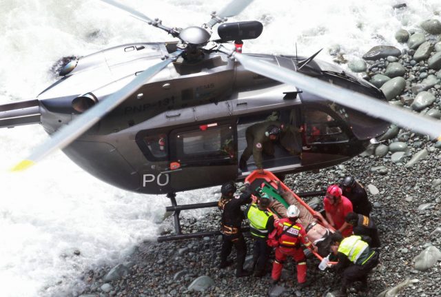 Rescue workers load an injured man on a stretcher (Vidal Tarky/Andina News Agency/AP)