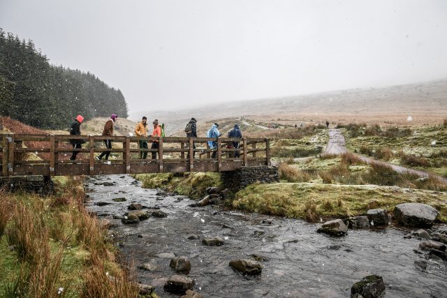 Walkers cross a footbridge n the Brecon Beacons (Ben Birchall/PA)