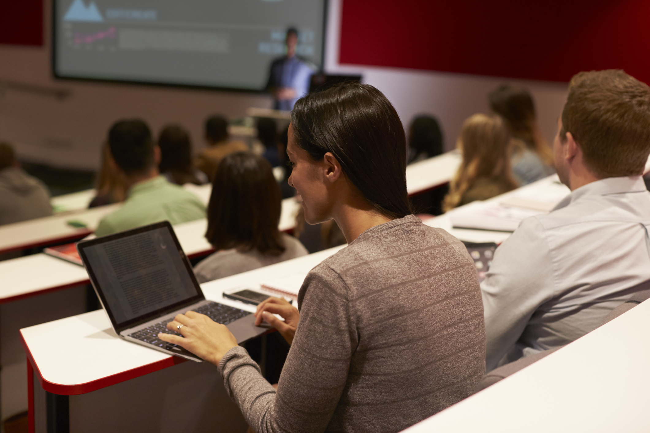 Woman using her laptop in a lecutre (monkeybusinessimages/Getty Images)