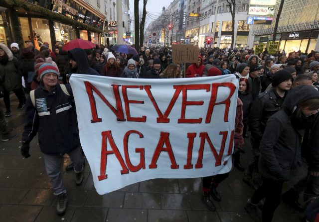 Some protesters carried placards reading 'Never Again' (Ronald Zak/AP)